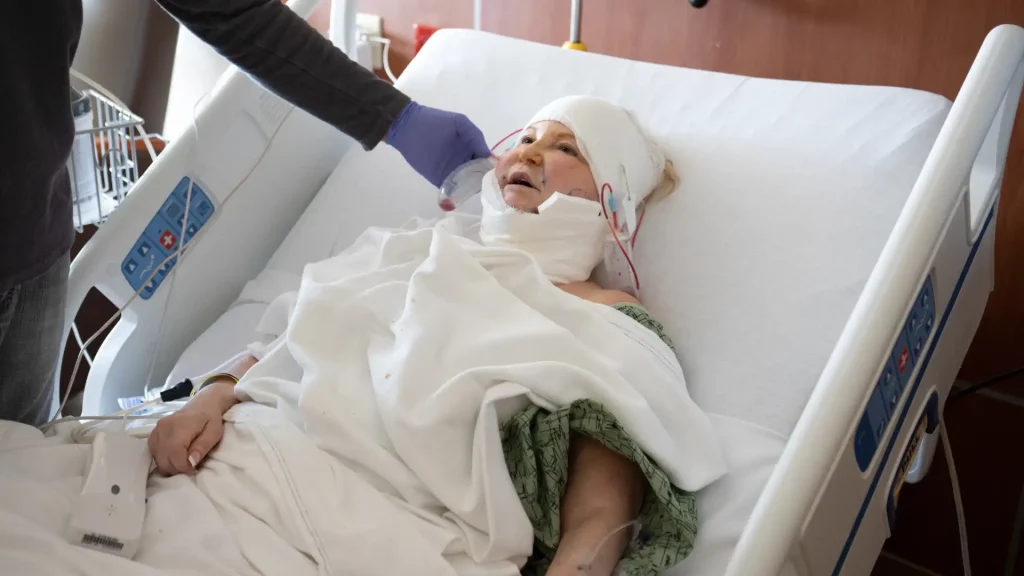 Injured patient in hospital bed receiving medical care