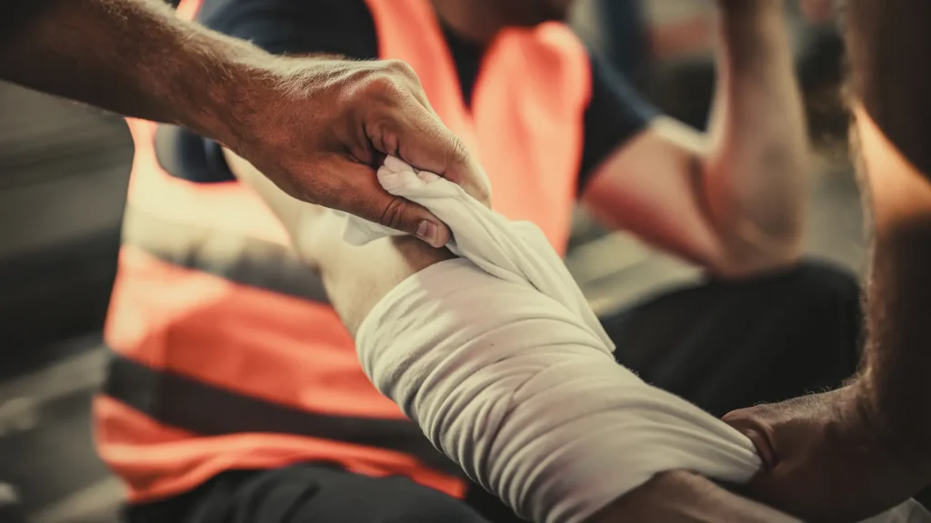 Person wrapping a bandage around an injured arm.