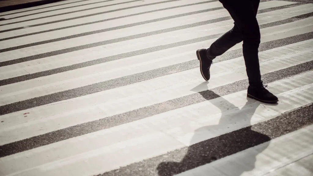 Close-up of a person running across a crosswalk