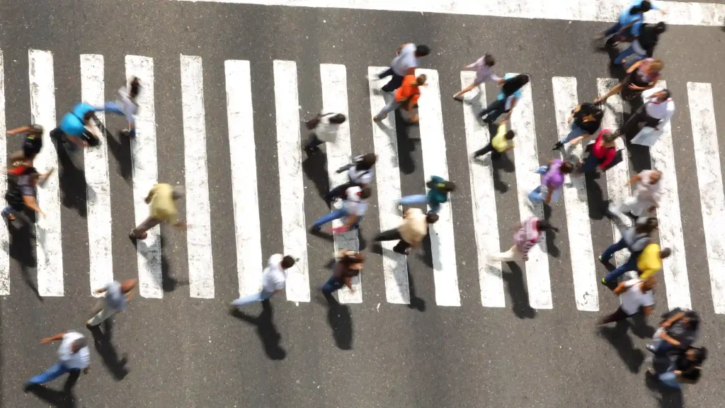 Overhead view of pedestrians crossing a striped crosswalk
