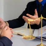 Scales of justice on desk as attorney consults client