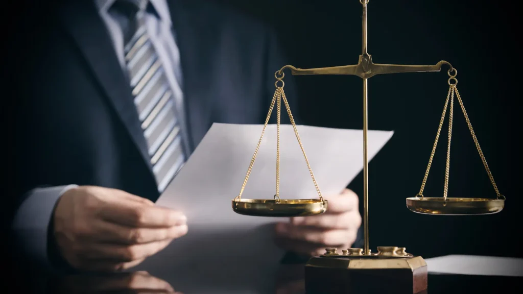 Attorney reviewing document beside brass scales of justice