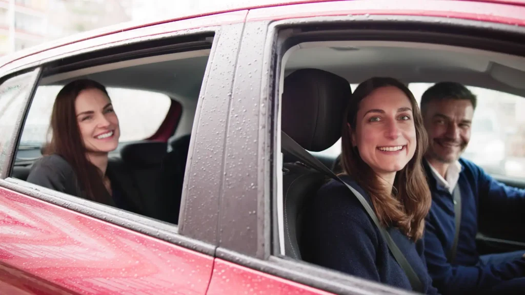 Smiling woman sitting in the back seat of a car.