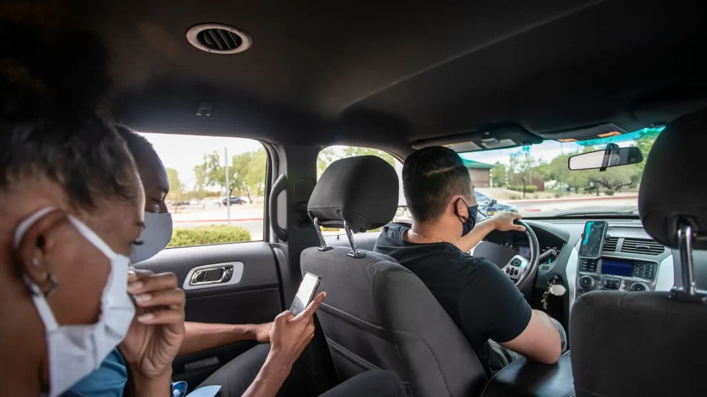 Masked rideshare driver and passenger inside vehicle