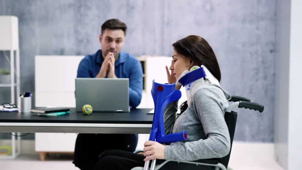 Injured woman with neck brace and crutches talking to a man at a desk