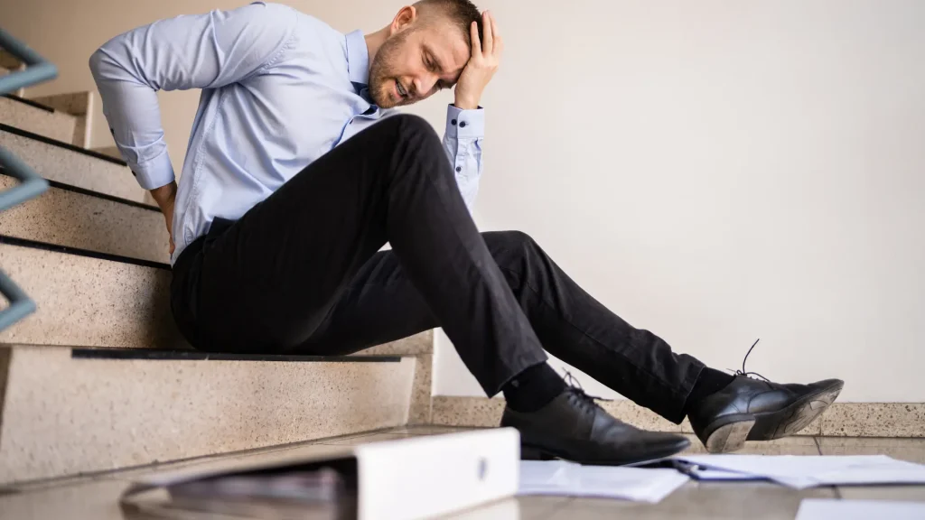 Man holding his head in pain after falling on stairs