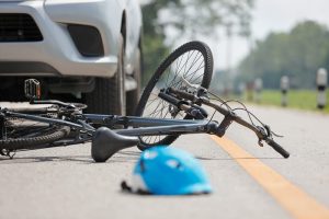 Bicycle fallen over in front of car.